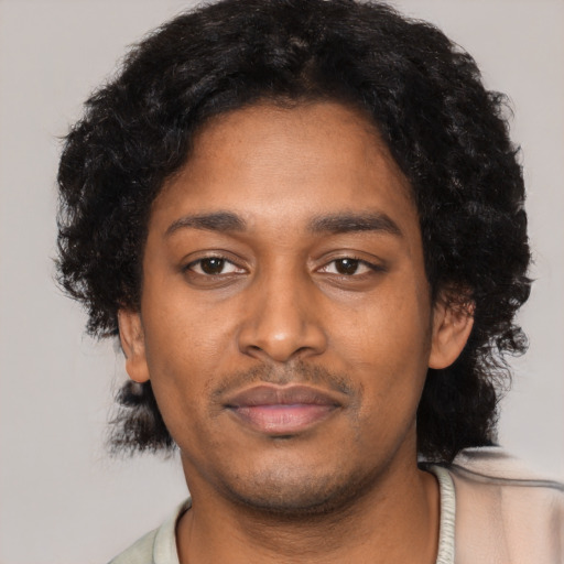 Joyful black young-adult male with short  black hair and brown eyes