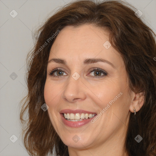 Joyful white adult female with long  brown hair and brown eyes