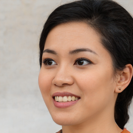 Joyful asian young-adult female with long  brown hair and brown eyes