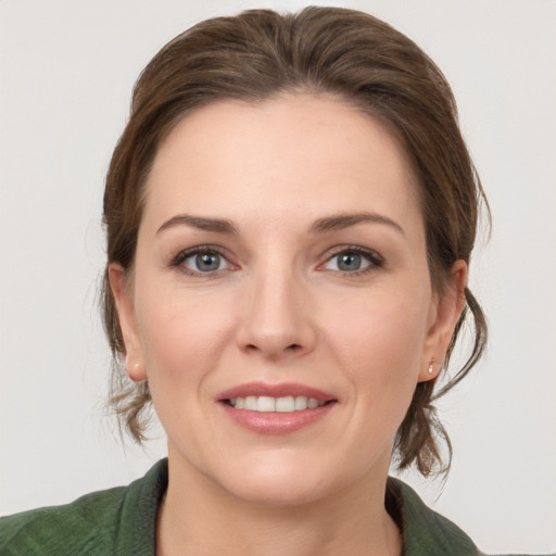 Joyful white young-adult female with medium  brown hair and grey eyes