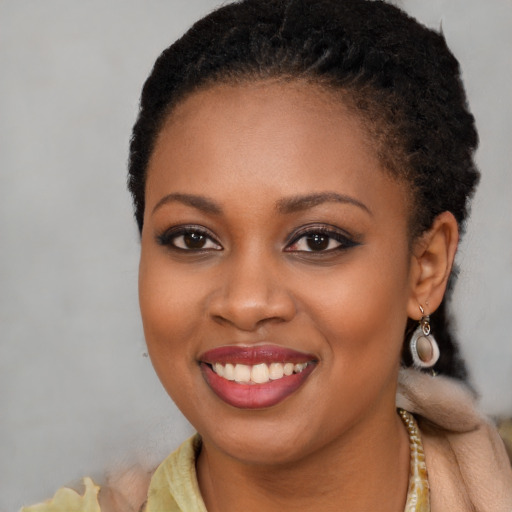 Joyful black young-adult female with long  brown hair and brown eyes
