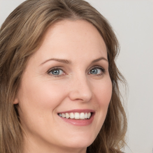 Joyful white young-adult female with long  brown hair and grey eyes