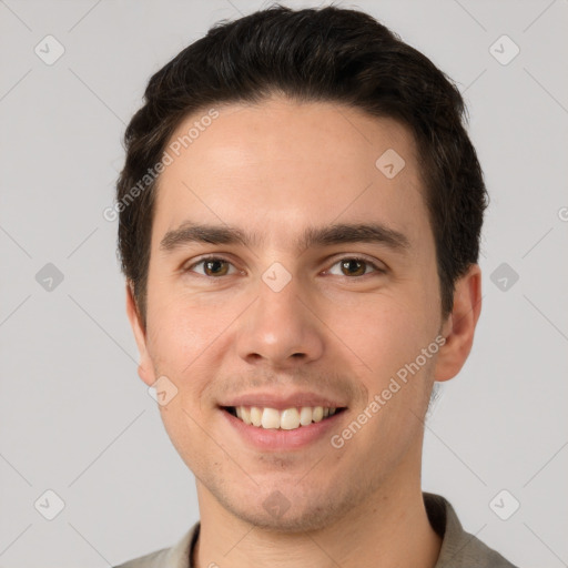 Joyful white young-adult male with short  brown hair and grey eyes