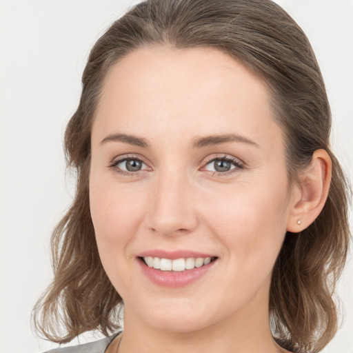 Joyful white young-adult female with medium  brown hair and grey eyes