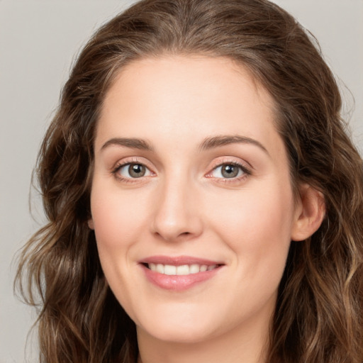 Joyful white young-adult female with long  brown hair and green eyes