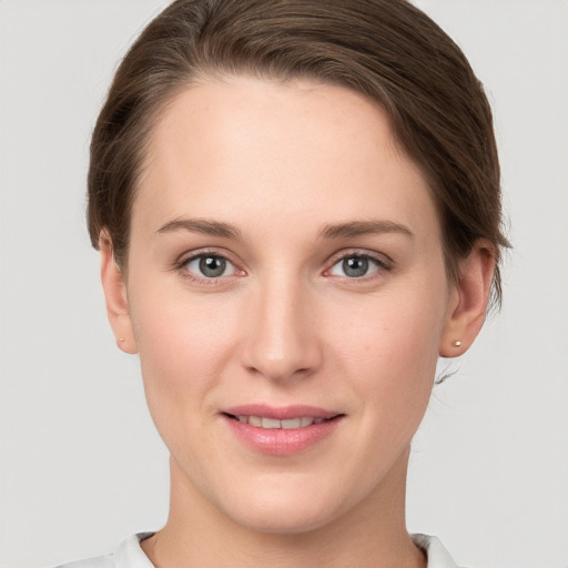 Joyful white young-adult female with short  brown hair and grey eyes