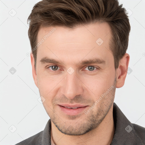 Joyful white young-adult male with short  brown hair and grey eyes