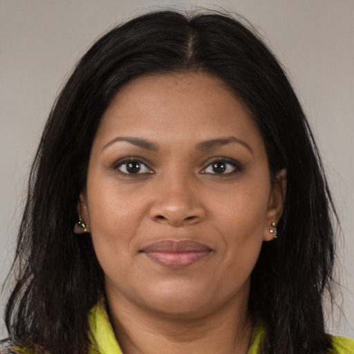 Joyful black young-adult female with long  brown hair and brown eyes
