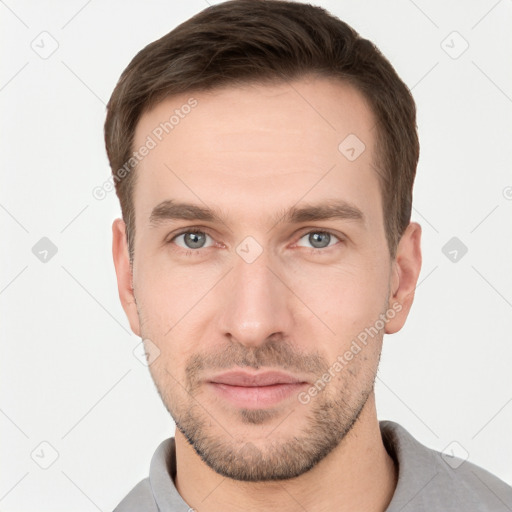 Joyful white young-adult male with short  brown hair and grey eyes