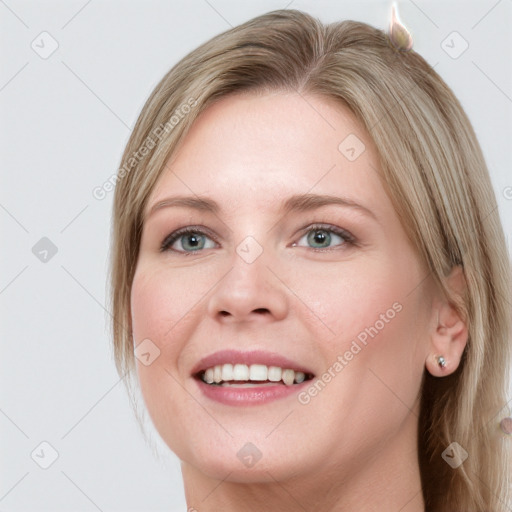 Joyful white young-adult female with long  brown hair and blue eyes