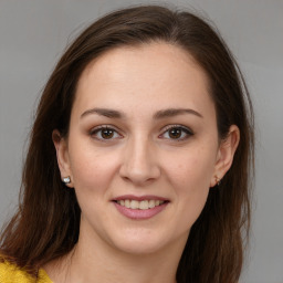 Joyful white young-adult female with long  brown hair and brown eyes