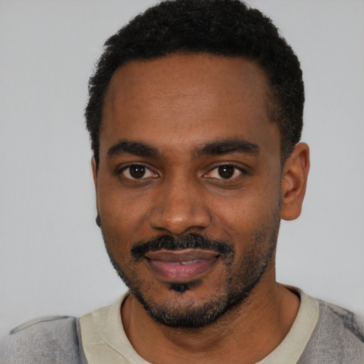 Joyful black young-adult male with short  black hair and brown eyes