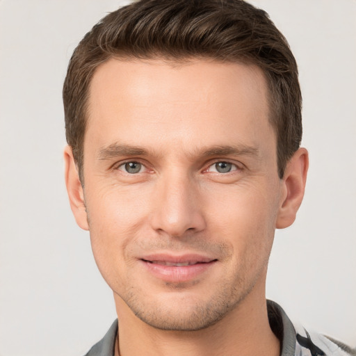 Joyful white young-adult male with short  brown hair and grey eyes