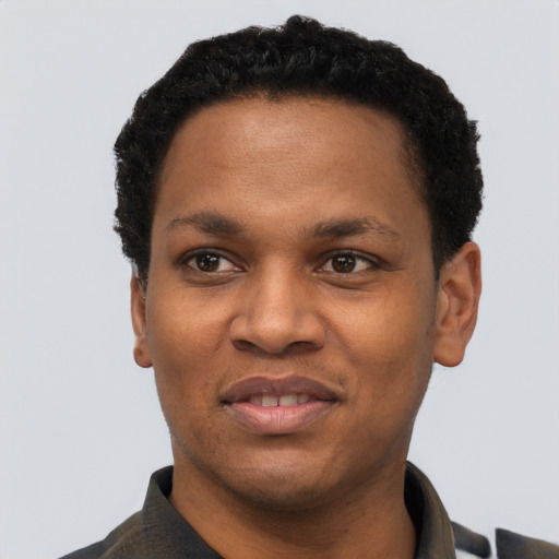Joyful black young-adult male with short  black hair and brown eyes