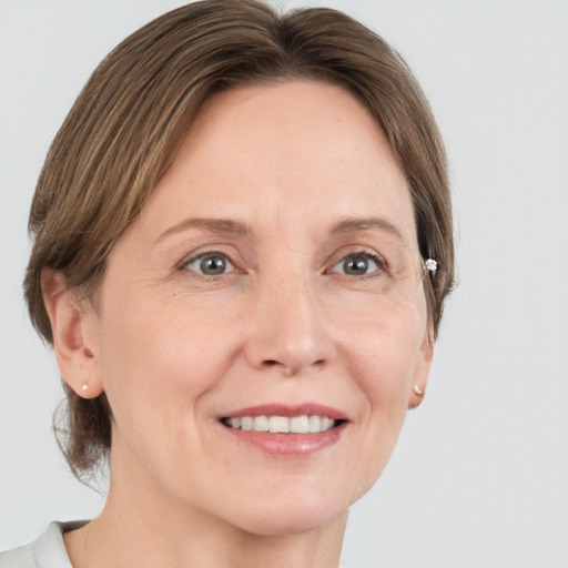 Joyful white adult female with medium  brown hair and grey eyes