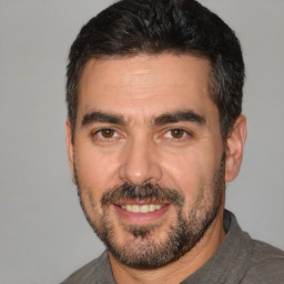 Joyful white adult male with short  black hair and brown eyes
