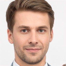 Joyful white young-adult male with short  brown hair and grey eyes