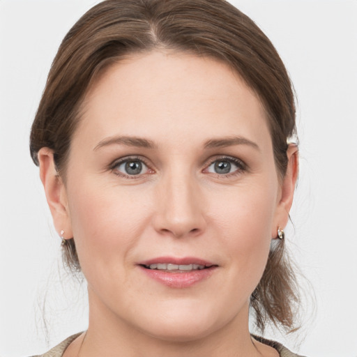 Joyful white young-adult female with medium  brown hair and grey eyes