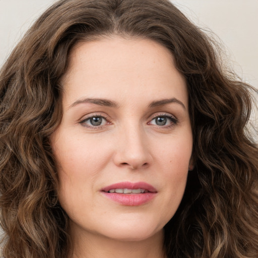 Joyful white young-adult female with long  brown hair and green eyes