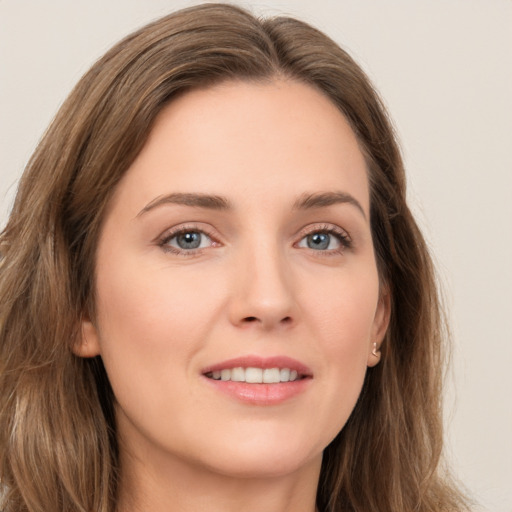 Joyful white young-adult female with long  brown hair and green eyes