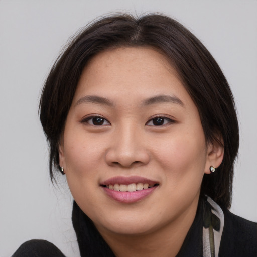 Joyful asian young-adult female with medium  brown hair and brown eyes