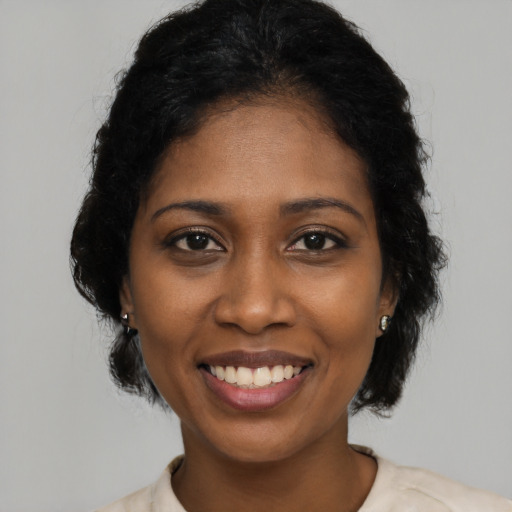 Joyful black young-adult female with medium  black hair and brown eyes