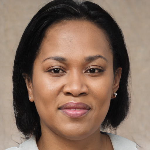 Joyful black adult female with medium  brown hair and brown eyes