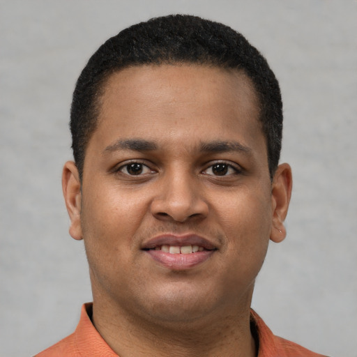 Joyful latino young-adult male with short  brown hair and brown eyes