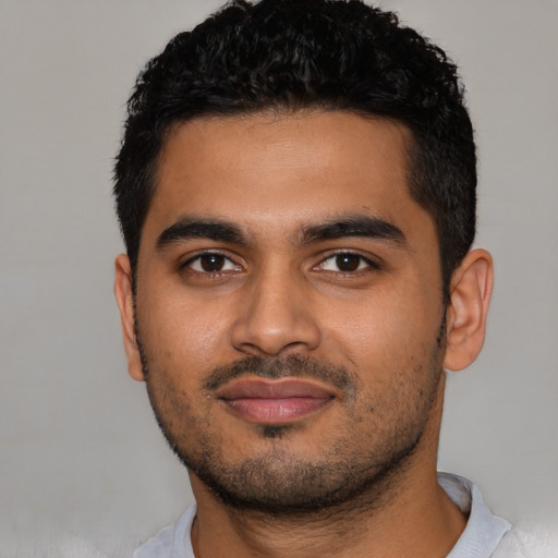 Joyful latino young-adult male with short  black hair and brown eyes