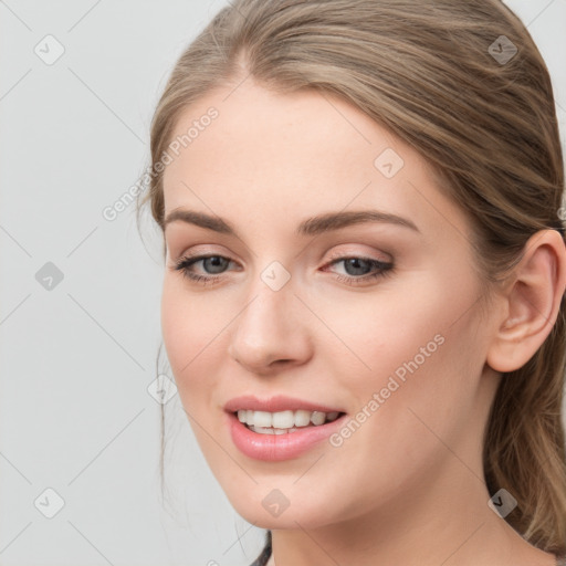 Joyful white young-adult female with long  brown hair and blue eyes