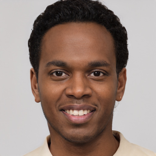 Joyful black young-adult male with short  black hair and brown eyes