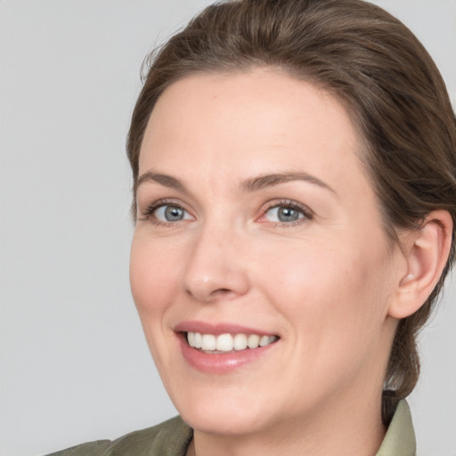 Joyful white adult female with medium  brown hair and grey eyes