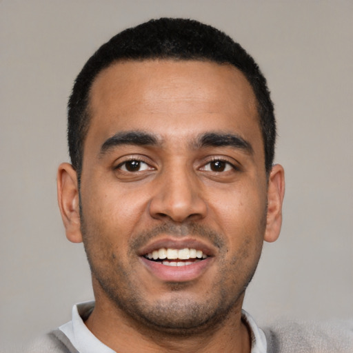 Joyful latino young-adult male with short  black hair and brown eyes