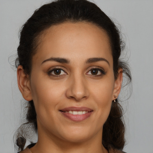 Joyful latino young-adult female with medium  brown hair and brown eyes