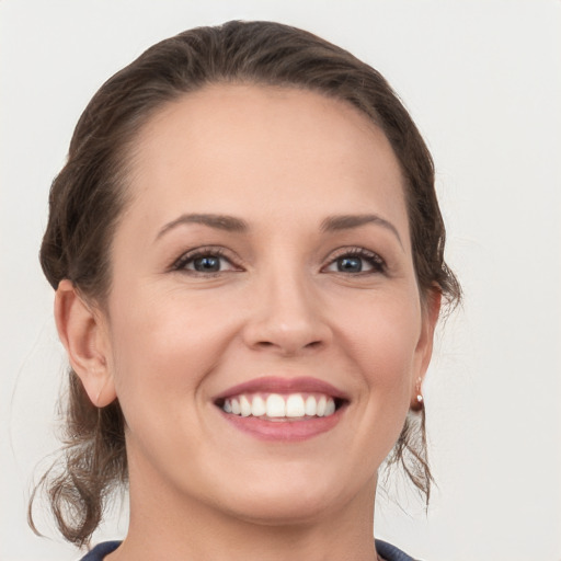 Joyful white young-adult female with medium  brown hair and grey eyes