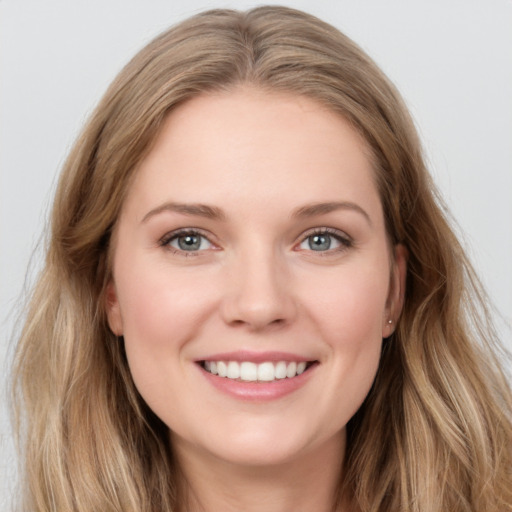 Joyful white young-adult female with long  brown hair and blue eyes