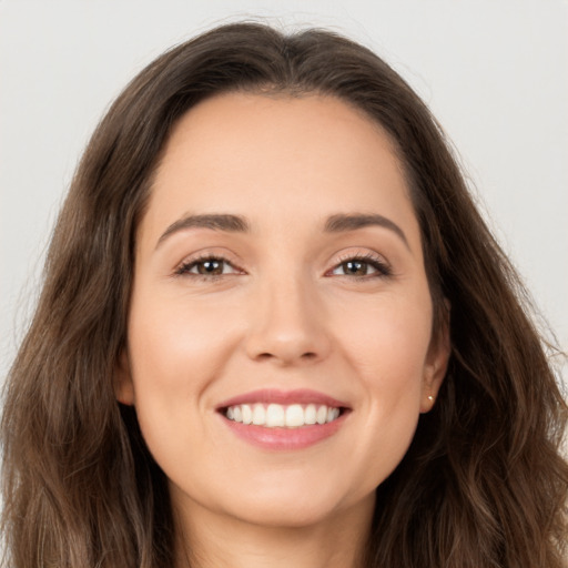 Joyful white young-adult female with long  brown hair and brown eyes