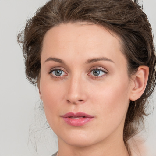 Joyful white young-adult female with medium  brown hair and blue eyes