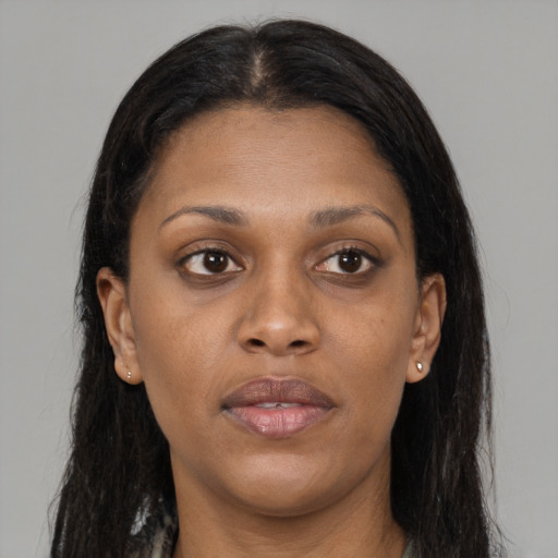 Joyful black young-adult female with long  brown hair and brown eyes