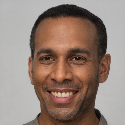 Joyful latino adult male with short  black hair and brown eyes