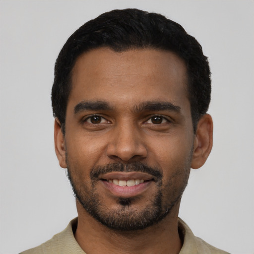 Joyful black young-adult male with short  black hair and brown eyes