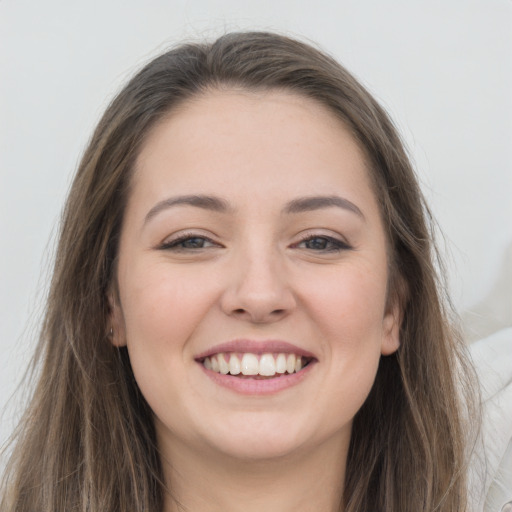 Joyful white young-adult female with long  brown hair and grey eyes