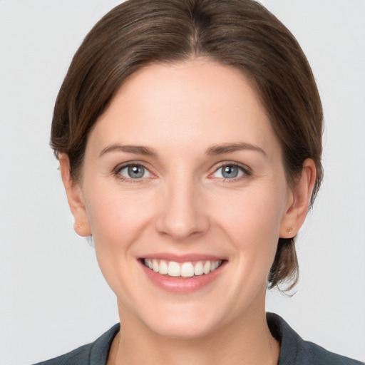 Joyful white young-adult female with medium  brown hair and grey eyes