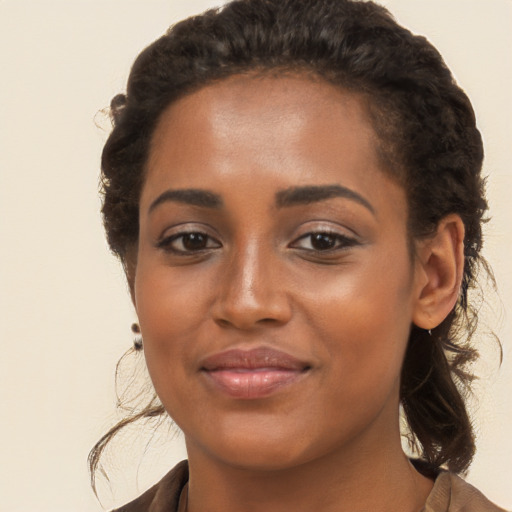 Joyful black young-adult female with long  brown hair and brown eyes