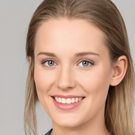 Joyful white young-adult female with long  brown hair and blue eyes