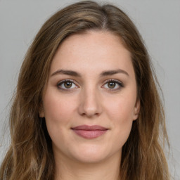 Joyful white young-adult female with long  brown hair and green eyes