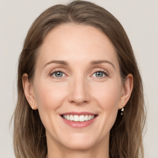 Joyful white adult female with medium  brown hair and grey eyes