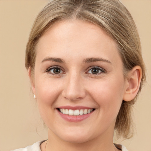 Joyful white young-adult female with medium  brown hair and grey eyes