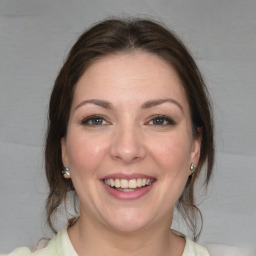 Joyful white young-adult female with medium  brown hair and green eyes