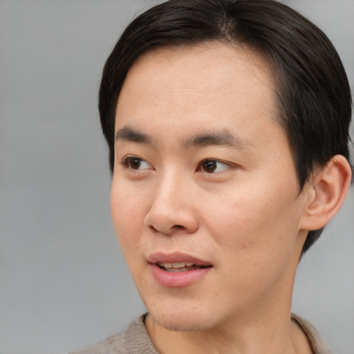 Joyful asian young-adult male with short  brown hair and brown eyes
